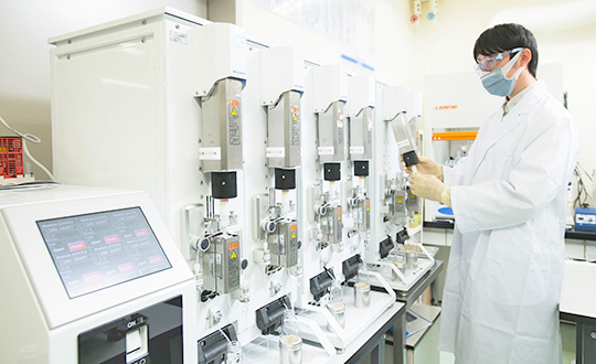 A chemist in white lab coat operating GO-EHT in a laboratory.